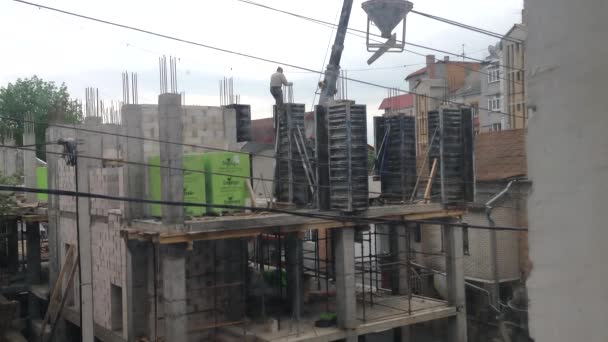 Vinnitsa, Ukraine - 5 juin 2021 : Un constructeur descend un moule dans lequel du béton est coulé. Travaux de construction d'un nouveau centre d'affaires. — Video