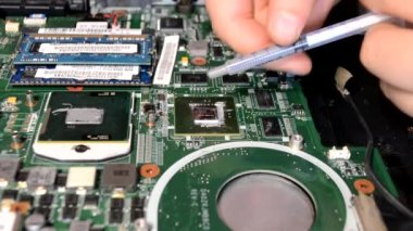 Kiev, Ukrayna - 18 Mayıs 2021: Dizüstü bilgisayar tamir merkezlerinden birinde şırıngadan CPU 'ya ısı tedavisi uygulamak.