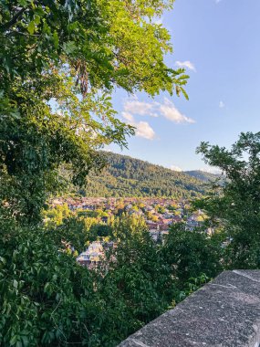 Bereketli yeşillik vadide yuvarlanan dağlar ve berrak mavi gökyüzü ile çevrili güzel bir kasaba oluşturuyor.