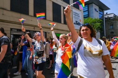 Karlsruhe, Almanya - 3 Haziran 2023: Gururu kutlayan, neşeli şehir ortamında gökkuşağı bayrakları sallayan, renkli bir geçit töreninde birlik ve çeşitliliği somutlaştıran bir grup insan