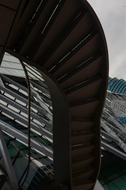 Steel Stairs ve Glass Building 'in soyut yapısı, cam bir yapı içinde sanatsal çelik merdiven spirali, eşsiz gölgeler, yaratıcı bir fotoğraf veya doğanın ilham verdiği görsel promosyon için harika..