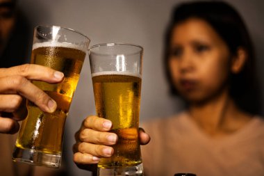 Kutlama tostu Soğuk Birayla, Arkadaşlar soğuk bira şişelerini kadeh kaldırır, yoğunlaşma şenlikli ışıkların altında damlar, neşeli bir fotoğraf veya parti ruhu gösterisi için mükemmeldir..