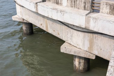 Deniz Üzerinde Beton Sütunlar Yapısı, beton sütunların çarpıcı bir fotoğrafı, parlak sudan yükselen uzun gri, kıyı mühendisliği veya mimari belgesel için mükemmel..