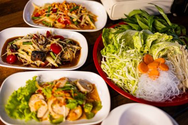 Çeşitli Som Tam ve Yum Yemek Masası, Som Tam ve Yum 'un canlı bir fotoğrafı, papaya salatası, yengeç, sosis, yum ve taze otlar, Tayland mutfağı veya kalın aromalı belgesel için mükemmel..