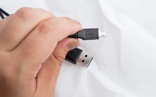 Hand Holding Black USB Cable iSolated on White