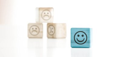 Üzgün emoticon ahşap küpleri önünde yeşil ahşap küpün üzerindeki gülümseme ifadesi 3 boyutlu resimleme