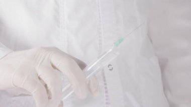 Doktorlar el bir şırınga tutarak