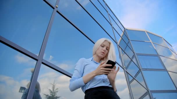 Blonde zakenvrouw met telefoon in handen — Stockvideo