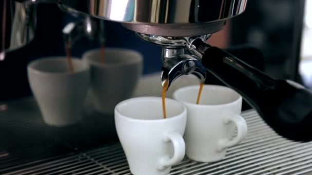 The cappuccino is poured into two mugs from the coffee machine — Stock Video
