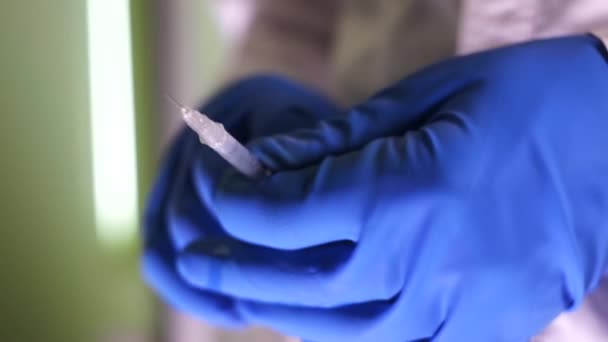 Доктор в синих перчатках собирает лекарство в шприц — стоковое видео