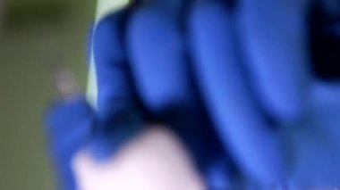 Doktor bir pamuklu çubukla losyonları ve aşılama yapar