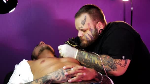 Tattoo kunstenaar in het proces van het maken van een tatoeage — Stockvideo