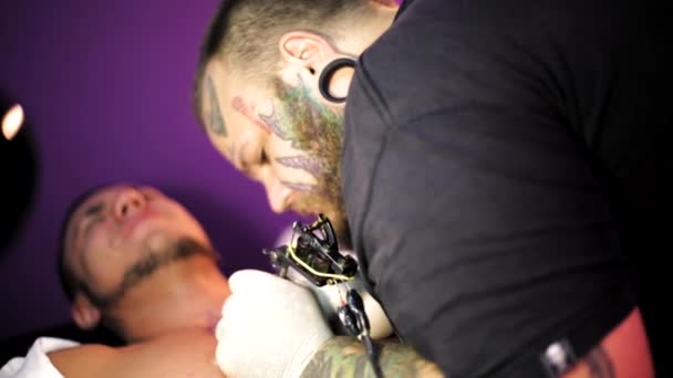 Tattoo artist in the process of making a tattoo — Stock Video