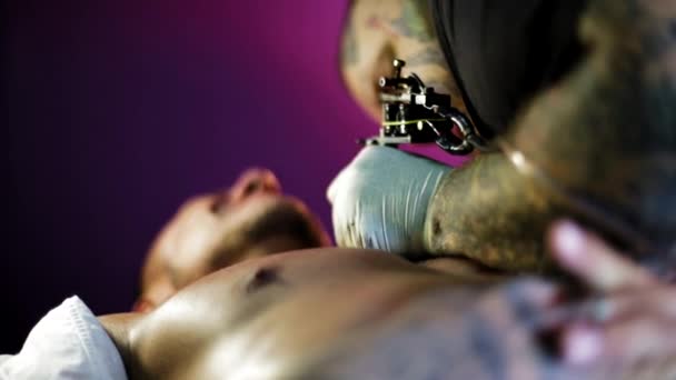 Tattoo kunstenaar in het proces van het maken van een tatoeage — Stockvideo