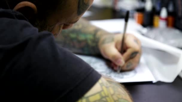 El artista prepara un boceto del tatuaje — Vídeos de Stock