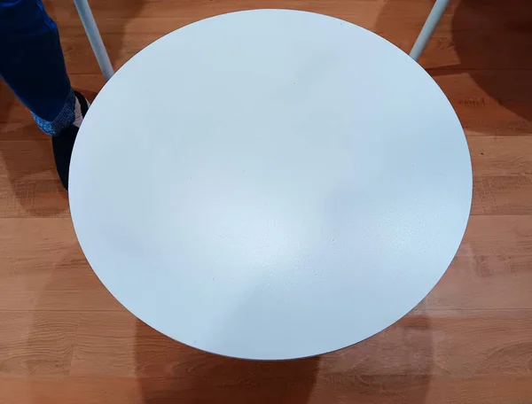 Genellikle ahşap zemin zemininde izole edilmiş lale masası olarak bilinen beyaz kaide masasının üst görüntüsü. Metin için alanı kopyala.