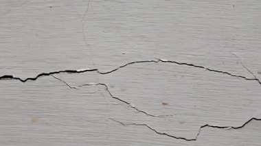 Beyaz bir duvardaki önemli yapısal çatlakların soyut dokusu.