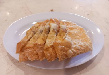 Endonezya Çin mutfağı, içi tatlı ve lezzetli tavuk etiyle dolu kızarmış hamur köfteleri mermer masada izole edilmiş beyaz tabakta..