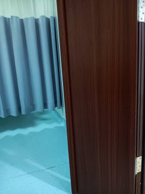 Beyaz ve gri tıbbi mahremiyet veya kabin perdesine ve hastanenin ahşap kapısına yakından bakın..