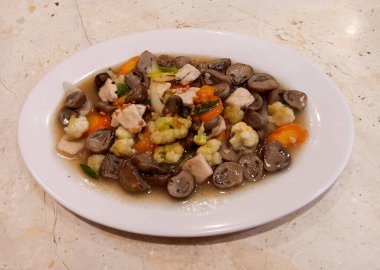 Endonezya Çin yemeği, tavuk ve mantar kızartması ya da mermer masada izole edilmiş beyaz tabakta ayam cah jamur. Görüntüyü kapat.