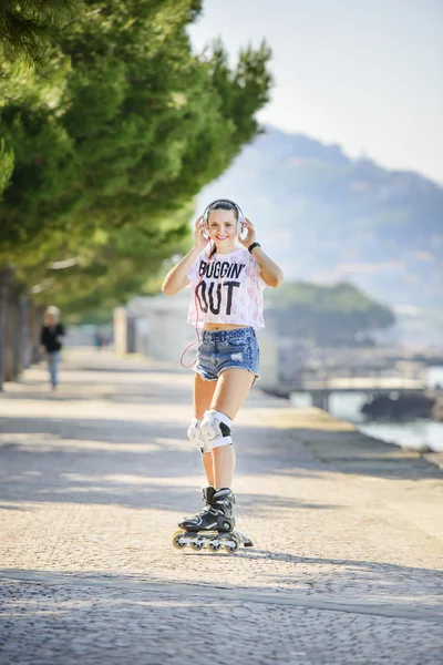 Tekerlekli paten Rıhtımlar üzerinde sürme kısa kot şortlu genç atlet