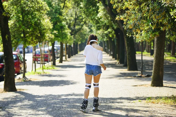 Молодий спортсмен в коротких джинсових шортах катається на роликах в парку — стокове фото