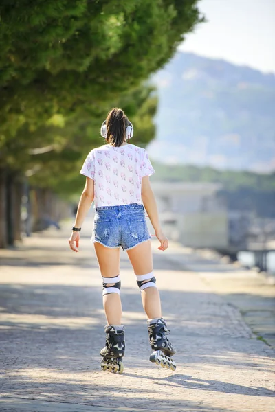 Tekerlekli paten Rıhtımlar üzerinde sürme kısa kot şortlu genç atlet