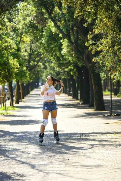 Tekerlekli paten üzerinde binme kısa kot şortlu genç atlet