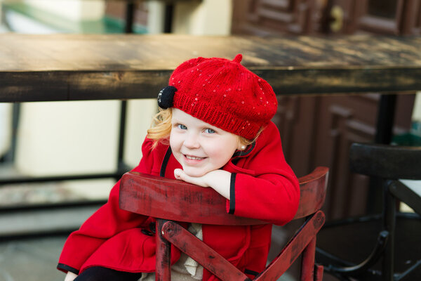 portrait of a little red-haired girl in city summer