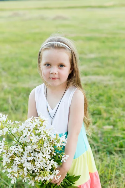 Retrato linda chica con flores en el prado — Foto de Stock