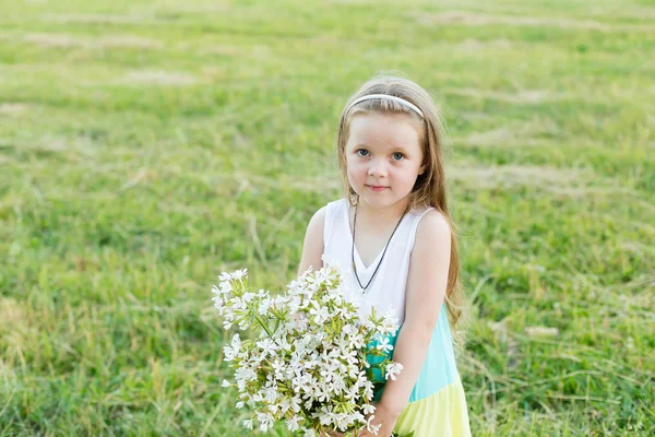 Retrato linda chica con flores en el prado — Foto de Stock