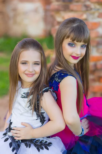 Foto de moda de dos hermosas chicas en un fondo de ru de ladrillo — Foto de Stock