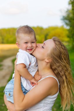 Bir çocukla bir çayırda dinlenme hamile anne.