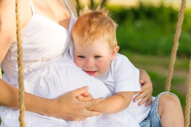 Bir çocukla bir çayırda dinlenme hamile anne.