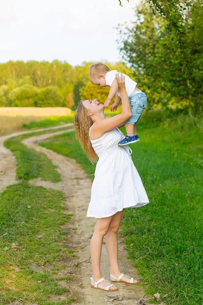 Embarazada mamá con un niño descansando en un prado . —  Fotos de Stock