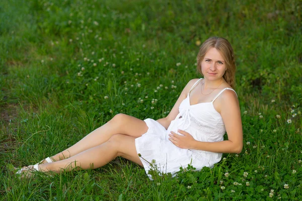 Portréja egy terhes nő ül a fűben — Stock Fotó