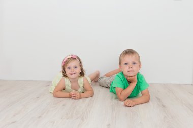 Küçük erkek ve kız yerde yatarken.