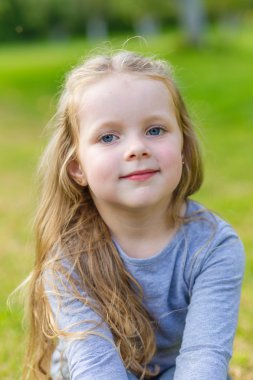 Uzun sarı saçlı sevimli bir kız portresi