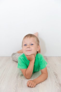 Yerde yatarken mavi gözlü yakışıklı çocuk