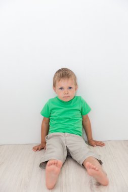 Katta oturan mavi gözlü yakışıklı çocuk