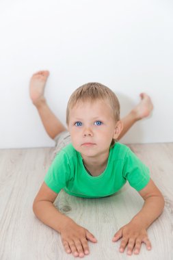 Yerde yatarken mavi gözlü yakışıklı çocuk