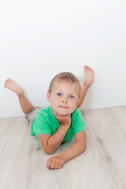 Yerde yatarken mavi gözlü yakışıklı çocuk