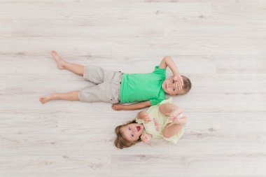 Küçük erkek ve kız yerde yatarken.