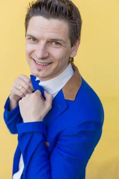 Portrait of a man in a blue jacket on a yellow background — Stock Photo, Image
