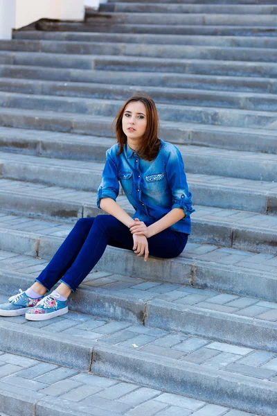 Portret van een mooi meisje in blauw op trappen — Stockfoto