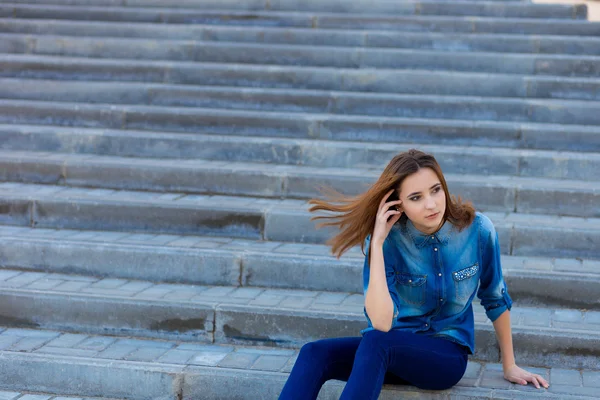 Porträt eines schönen Mädchens in Blau auf einer Treppe — Stockfoto