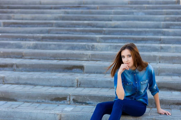 Portret van een mooi meisje in blauw op trappen — Stockfoto