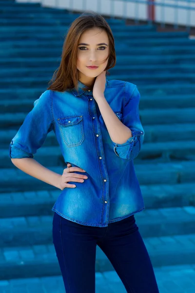 Portret van een mooi meisje in blauw op trappen — Stockfoto