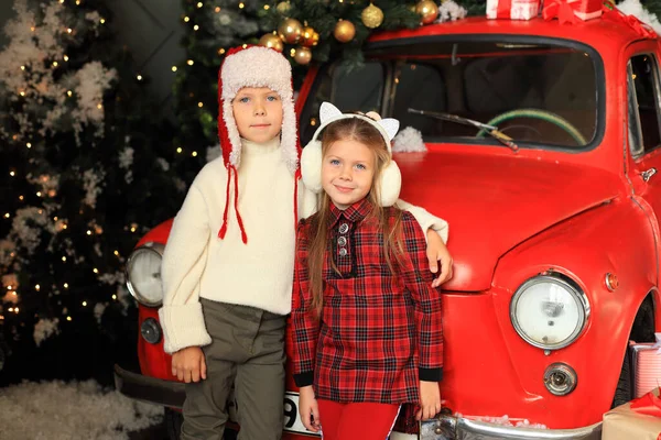 Niños en el fondo de un coche rojo con regalos de Año Nuevo. — Foto de Stock