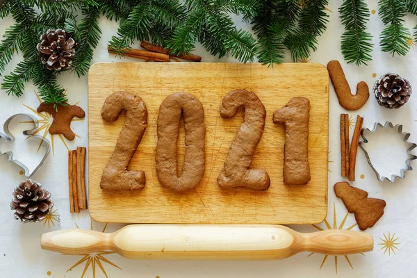 New Year lettering among fir trees and cookies